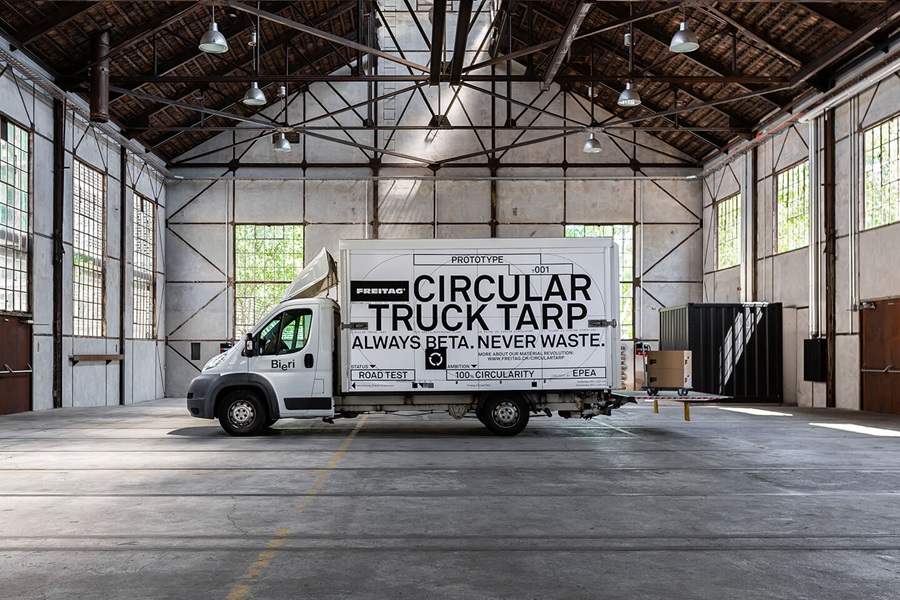 A white van with the black lettering on its side standing in a factory hall.