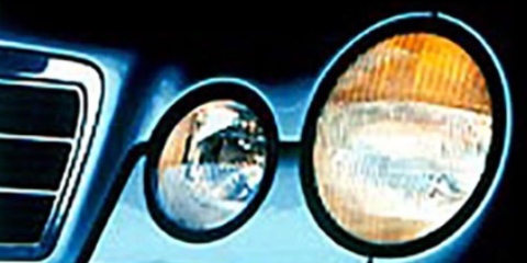 Close-up of the headlights of a blue car.