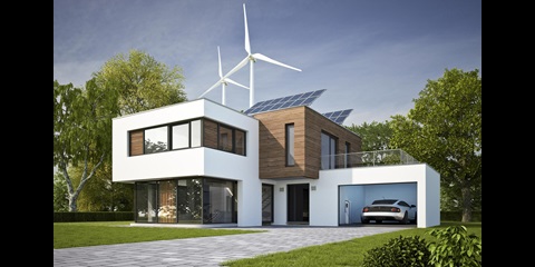 Modernes Wohnhaus mit Solardach und Windrädern im Hintergrund.